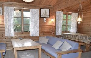 una sala de estar con un sofá azul en una cabaña de madera en Sandkassen, en Lønne Hede