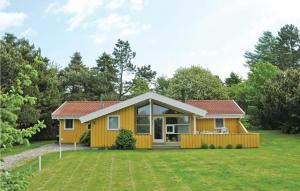 una pequeña casa amarilla con un gran patio en Cozy Home In Grsted With Kitchen en Udsholt Sand