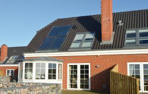 a red brick house with solar panels on the roof at Holiday Home Sdr Frankel Rømø Denm in Havneby