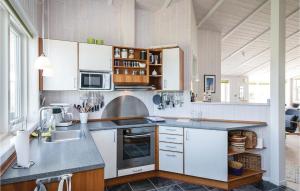 GrønhøjにあるStunning Home In Lkken With 3 Bedrooms, Sauna And Wifiの白いキャビネットとシンク付きのキッチン