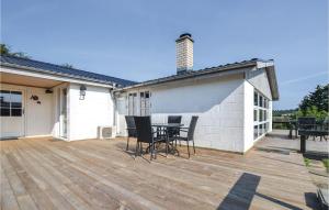 a patio with a table and chairs on a wooden deck at Amazing Home In Broager With Wifi in Broager