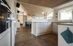 KelstrupにあるNice Home In Haderslev With 3 Bedrooms, Sauna And Wifiの白いキャビネット付きのキッチン、ダイニングルーム