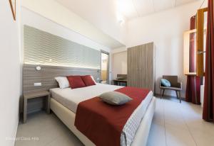 1 dormitorio con cama, escritorio y ventana en Ottocento Guest House, en Alghero