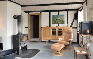 a living room with a wood stove and a chair at Gorgeous Home In Spttrup With Kitchen in Spottrup