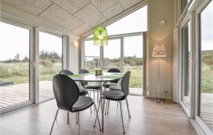 a dining room with a table and chairs and windows at Holiday Home Lyngvejen X in Klegod +12 photos
