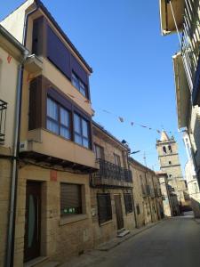 un callejón con un edificio y una torre de reloj en Arribes la corredera 3, en Aldeadávila de la Ribera