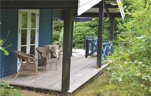 a porch with chairs and a table on a blue house at Beautiful Home In Grsted With Kitchen in Udsholt Sand
