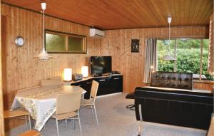 Kirke-Hyllinge的住宿－Amazing Home In Kirke Hyllinge With 3 Bedrooms，一间带桌子、书桌和电视的用餐室