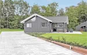 una pequeña casa gris con patio y césped en 4 Bedroom Awesome Home In Haderslev, en Kelstrup Strand