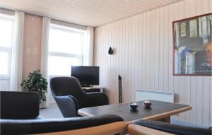 a living room with a table and chairs and a television at 2 Bedroom Cozy Apartment In Hvide Sande in Havrvig