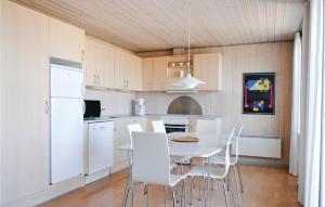 a kitchen with a white table and white chairs at 2 Bedroom Cozy Apartment In Hvide Sande in Havrvig