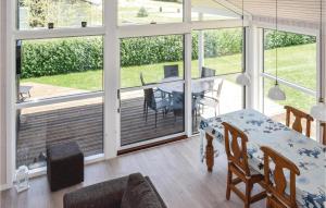 Habitación con mesa, sillas y balcón. en Nice Home In Rudkbing With Kitchen, en Spodsbjerg