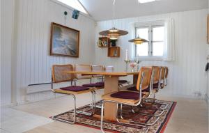 a dining room with a wooden table and chairs at Beautiful Home In Grsted With Private Swimming Pool, Can Be Inside Or Outside in Udsholt Sand