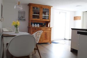 シュタウフェン・イム・ブライスガウにあるFerienwohnung Im Weingewölbeのキッチン(テーブル、椅子、木製キャビネット付) +12枚の写真