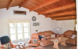 a living room with leather couches and a table at Holiday Home Bøtø Ringvej in Marielyst