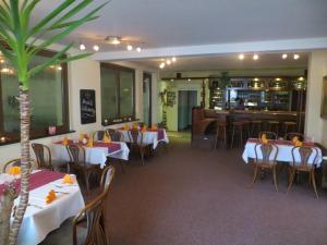 a restaurant with tables and chairs and a bar at Heidehotel Letzlingen in Letzlingen