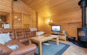 a living room with a couch and a table and a tv at Holiday Home Mads's Plantage Hadsund Xi in Helberskov