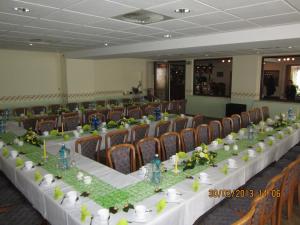 a long table in a room with chairs at Heidehotel Letzlingen in Letzlingen