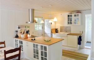 a kitchen with white cabinets and a counter top at Lovely Home In Rm With Wifi in Bolilmark