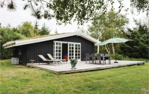 a black shed with a table and chairs and an umbrella at Lovely Home In Rm With Wifi in Bolilmark