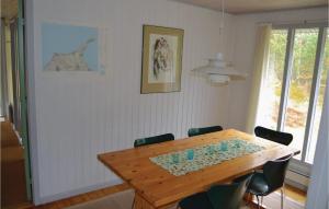 a dining room with a wooden table and chairs at Holiday Home Uranusvej in Ålbæk