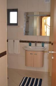 uma casa de banho com um lavatório e um espelho em Jardins de Pera vila M em Pêra