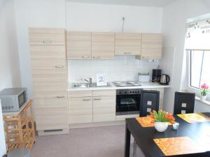 uma cozinha com armários de madeira e uma bancada em 5x Fuchs-Dobry Balkon-Apartments 40qm-65qm em Oberhausen