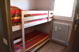 Łóżko lub łóżka piętrowe w pokoju w obiekcie Sestriere Short Breaks - L'arcobaleno