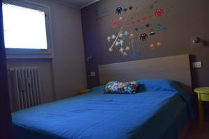 - une chambre avec un lit doté de draps bleus et une fenêtre dans l'établissement Sestriere Short Breaks - L'arcobaleno, à Sestrières