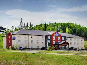 a large building with a red and white building at Lakeview Inns & Suites - Slave Lake in Slave Lake