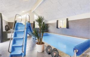 una piscina con scivolo blu e una pianta di Awesome Home In Frederiksvrk With Kitchen a Melby