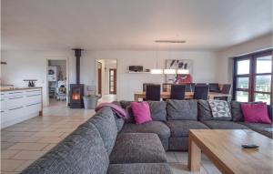 un soggiorno con divano grigio e una cucina di Four-Bedroom Holiday Home In Humble a Humble