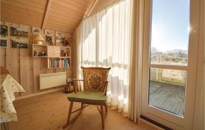 een kamer met een stoel en een groot raam bij 2 Bedroom Awesome Home In Hovborg in Hovborg