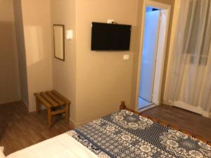 a bedroom with a bed and a television on the wall at Tulip Hotel in Cairo