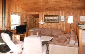 a living room with a couch and a table at Beautiful Home In Pandrup With 3 Bedrooms, Sauna And Wifi in Rødhus