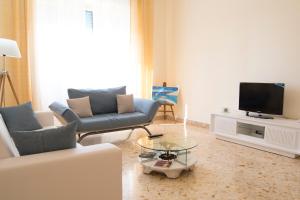 un soggiorno con 2 divani e una TV di Antica Akragante Apartment Agrigento con parcheggio a Agrigento
