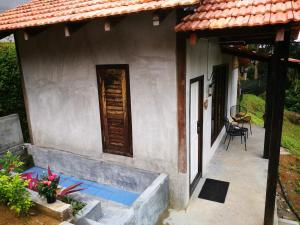 Cette petite maison dispose d'une terrasse couverte. dans l'établissement Nature Fruit Farm - Private Estate, à Balik Pulau