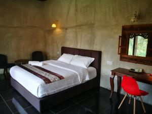 um quarto com uma cama, uma secretária e uma cadeira vermelha em Nature Fruit Farm - Private Estate em Balik Pulau