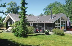 a house with a tree in front of it at Cozy Home In Vggerlse With Wifi in Bøtø By
