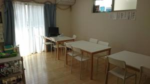 a dining room with tables and chairs and a window at バイキング樫本 in Hirakata