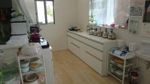 a kitchen with white cabinets and a counter top at バイキング樫本 in Hirakata