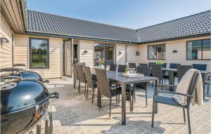a patio with a table and chairs and a grill at Lovely Home In Nørre Nebel With Wifi in Nørre Nebel