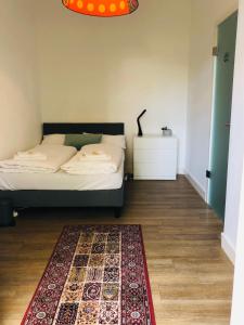 una camera da letto con un letto e un tappeto sul pavimento di Jaspers Boutique Rooms a Berlino