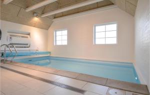 ein großer Pool mit blauem Wasser in einem Zimmer in der Unterkunft 6 Bedroom Awesome Home In Ringkøbing in Nørre Lyngvig