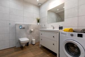 a bathroom with a washing machine and a sink at Amare Apartments A1 in Mosty