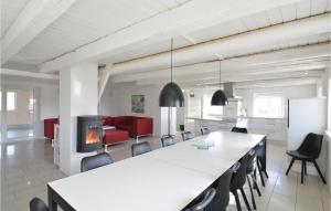 eine Küche und ein Wohnzimmer mit einem großen Tisch und Stühlen in der Unterkunft 6 Bedroom Awesome Home In Ringkøbing in Nørre Lyngvig