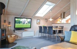 BjerregårdにあるAwesome Home In Hvide Sande With Wifiのリビングルーム(テレビ、テーブル、椅子付)