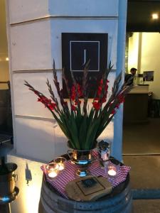 un vaso con fiori rossi e candele su un tavolo di Jaspers Boutique Rooms a Berlino