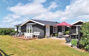 una casa negra con patio y patio en Lovely Home In Ringkbing With Kitchen, en Søndervig