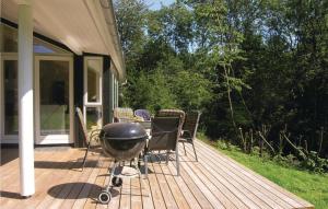 einen Grill auf einem Deck neben einem Haus in der Unterkunft Stunning Home In Rnne With Kitchen in Rønne